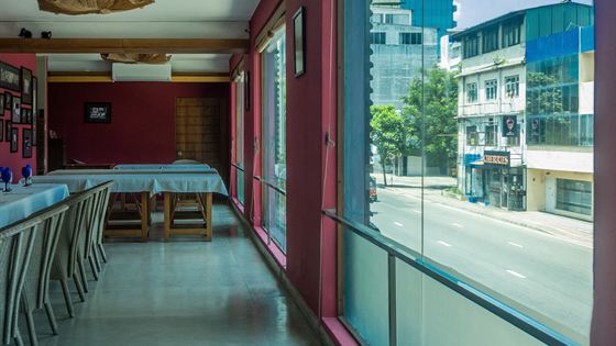 A view out from inside Colombo Court onto the street, a high-rise building beyond the glass.