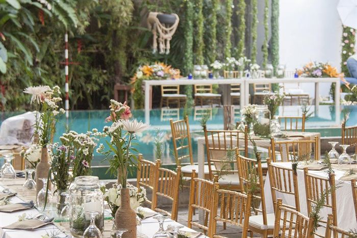 Long tables set with white linen and flowers beside the pool at Colombo Court for an event.