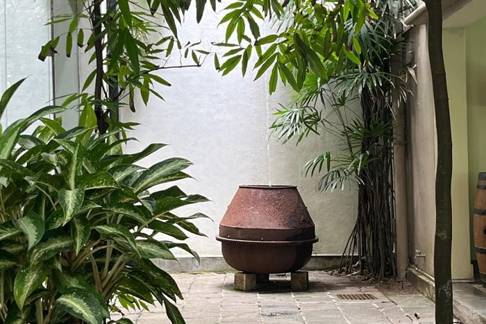 An old cement mixer turned into a fountain in a planted corner of the private courtyard at Colombo Court.
