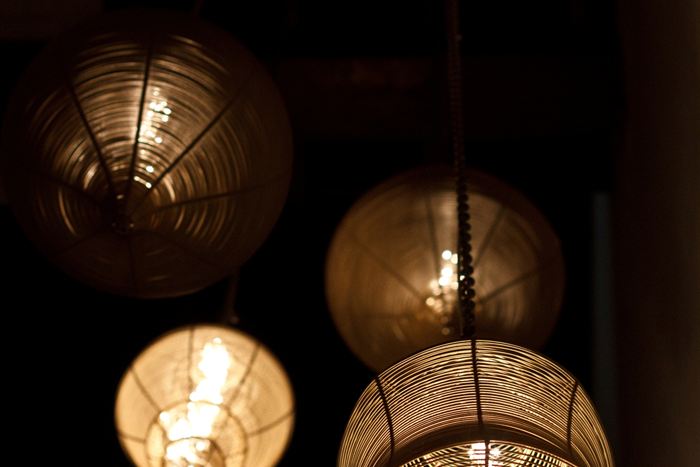 Brass and glass pendant lights hanging against a dark interior at Colombo Court.