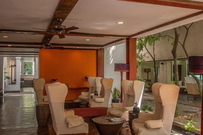 The library lounge at Colombo Court, wingback chairs and timber beams under warm light.
