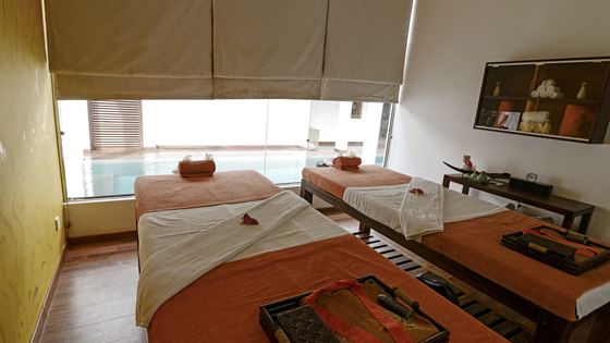 A treatment room at The Court Spa, a bed made up with folded towels and oils set out beside it.