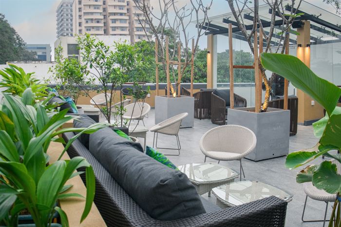 Rooftop seating at Cloud Café & Bar under its glass roof, planted beds between the tables.