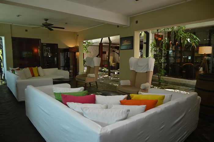 A long low sofa in a lounge at Colombo Court, cushions and lamps under a timber ceiling.