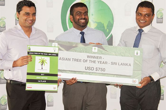 Four people holding an oversized winner&rsquo;s cheque for Asian Tree of the Year Sri Lanka in front of a green backdrop.