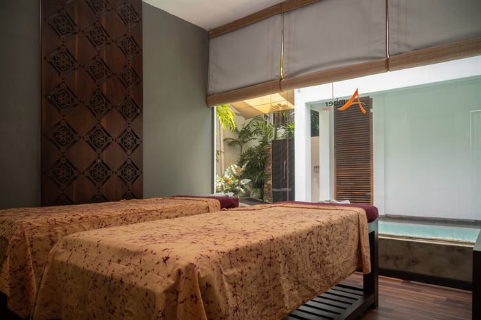 A room at Colombo Court with the window open onto greenery and the pool beyond.