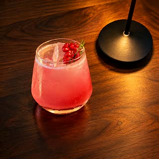 The Crimson Peach, a pink cocktail over ice with pomegranate seeds at Cloud Café & Bar.