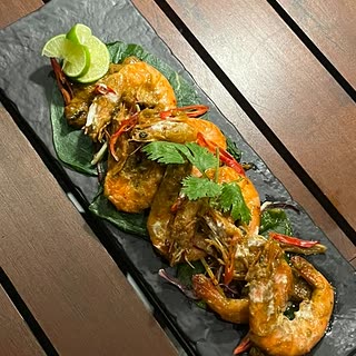Golden coconut prawns on a slate board with lime at Cloud Café & Bar.