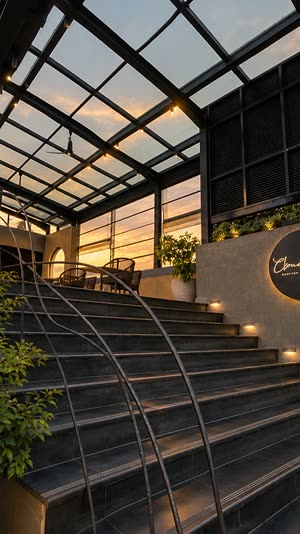 The stair up to Cloud Caf&eacute; & Bar under the glass roof, the sign at the top and the evening sky beyond.