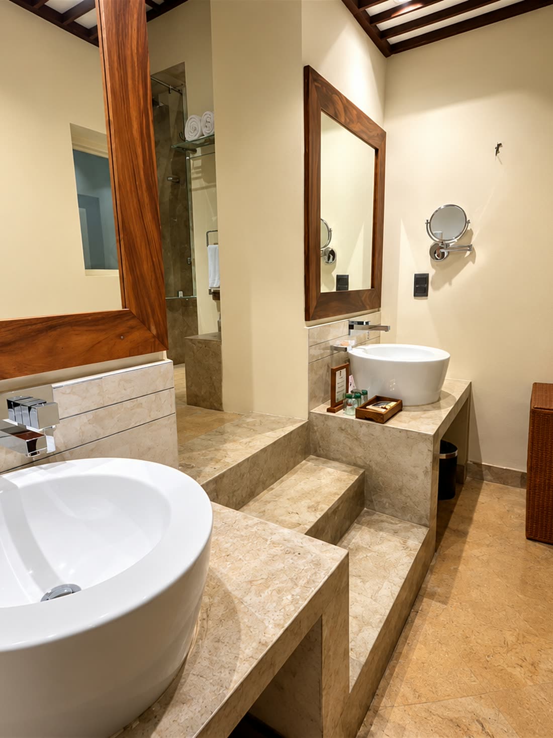 The Luxury Duplex Suite bathroom, a round basin on a stone counter under a timber-framed mirror.