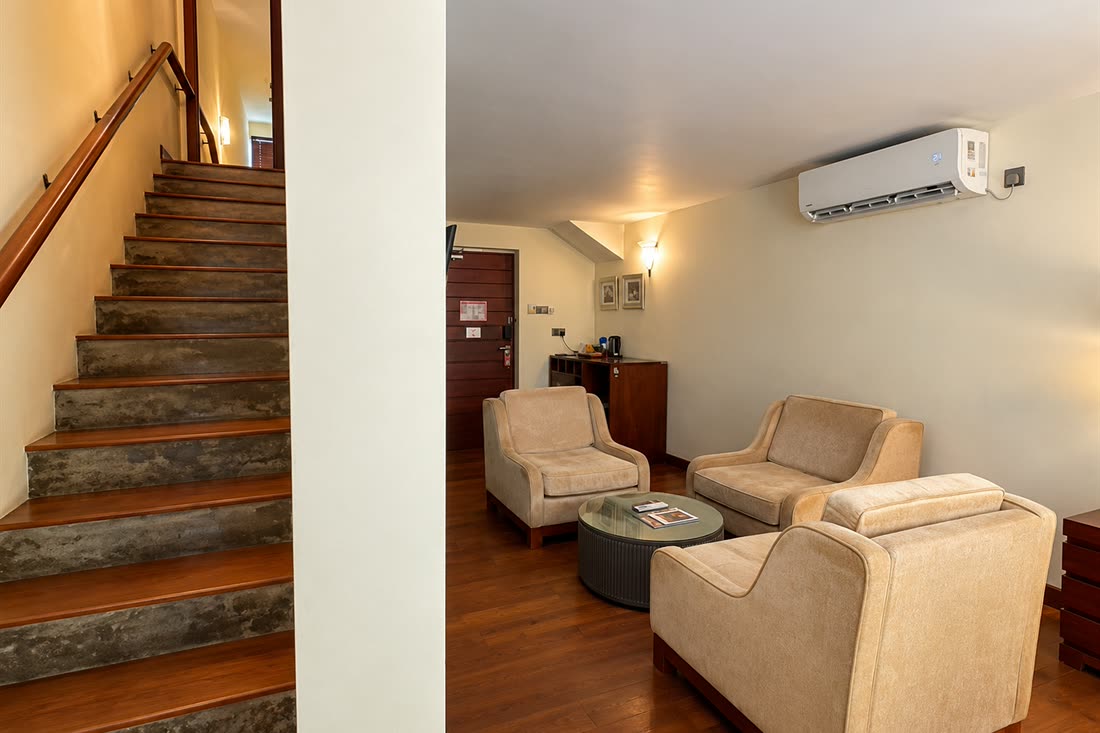 The sitting room of the Luxury Duplex Suite with the staircase rising to the bedroom above.