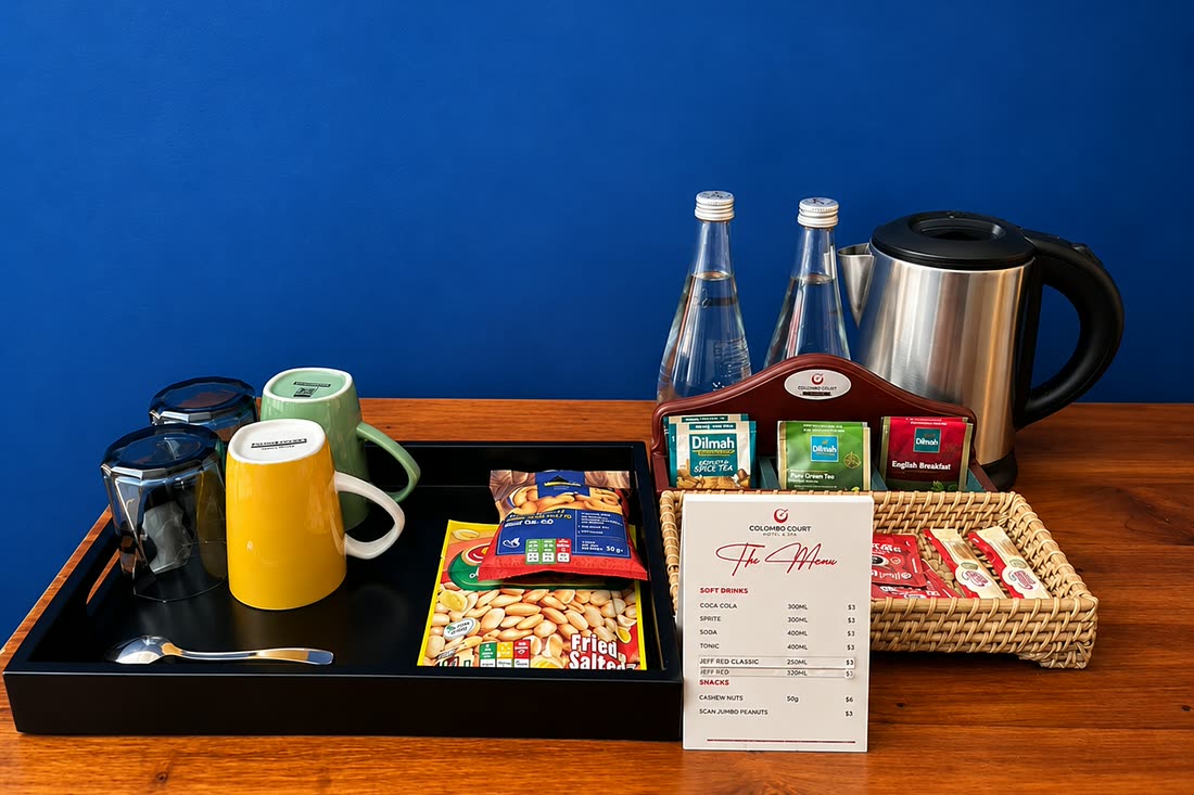 The tea and snack tray in the Luxury Honeymoon Suite, glass bottles, a kettle and biscuits on the timber counter.