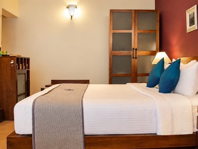 A Superior Deluxe room seen from the door, the king bed, timber cabinets and the television on the wall.