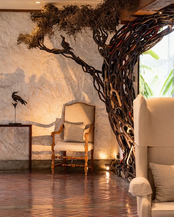 The steel tree in the lobby at Colombo Court, its trunk and branches welded from scrap, a winged armchair beneath.