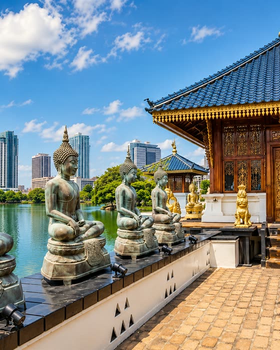 The Buddha statue at the lakeside shrine of Gangaramaya with the Colombo skyline behind it.