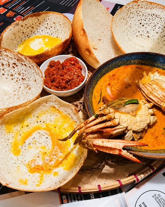 A Sri Lankan seafood feast on a woven tray: crab, prawns, curries and sambols around a mound of rice.