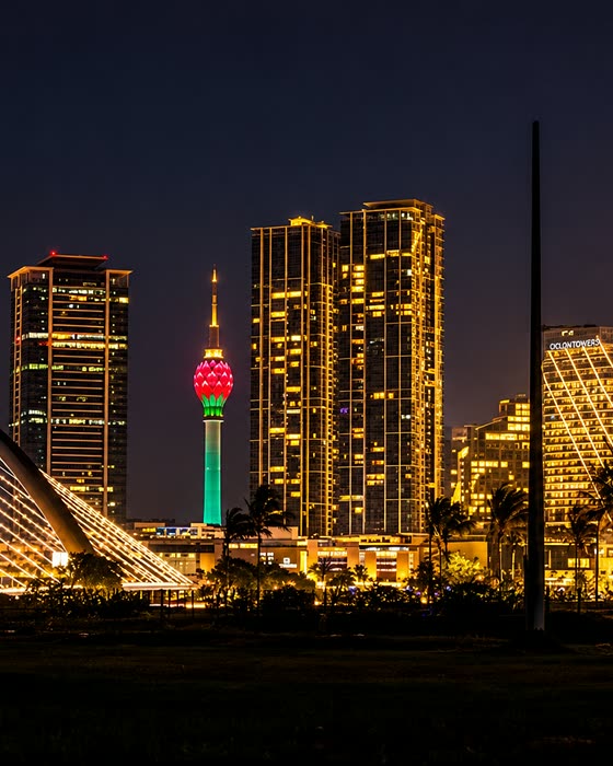 Colombo after dark, the lights of the modern city skyline glowing gold.